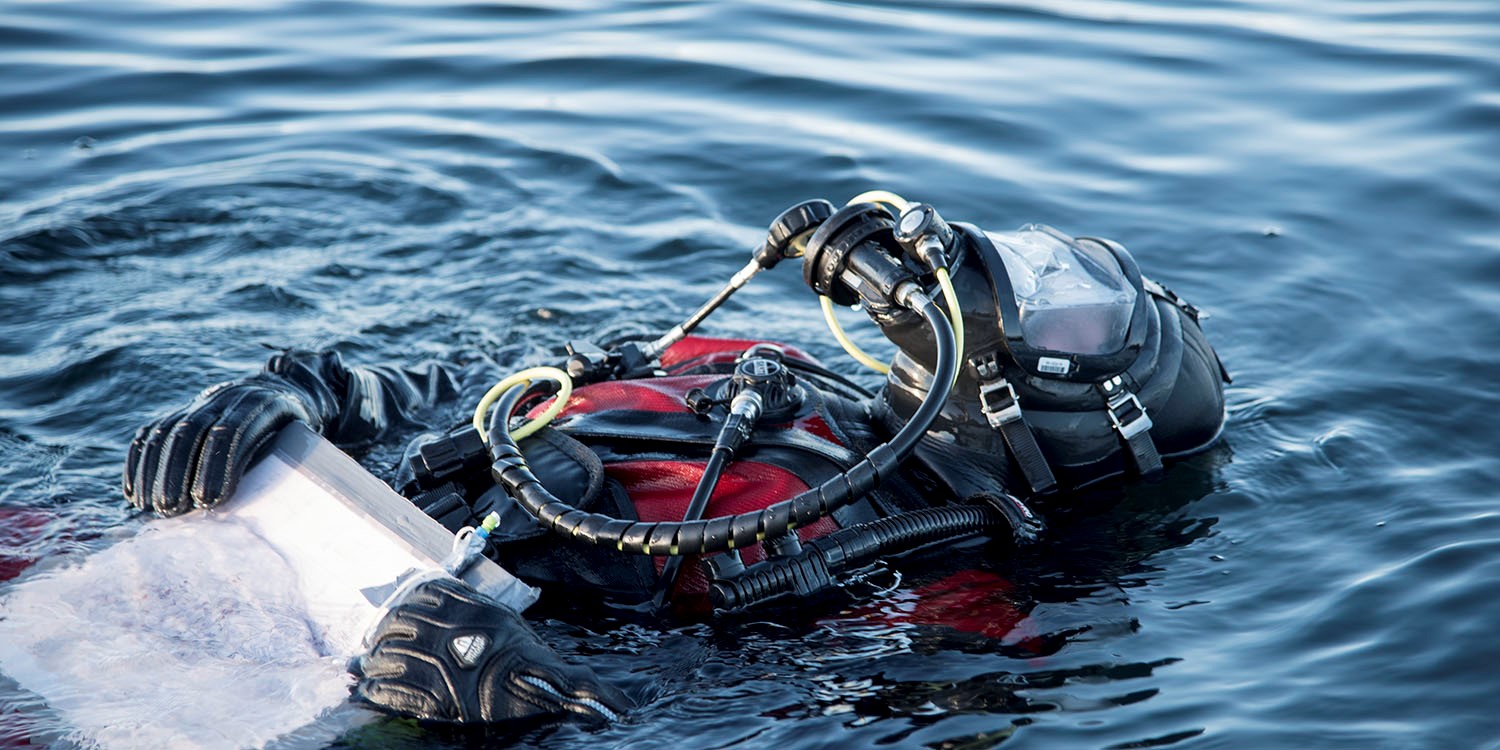 En dykare ligger och flyter på havsytan.