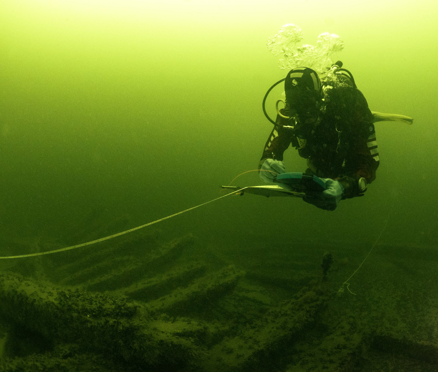 En dykare ser ut att göra anteckningar på en skärm under vattnet.