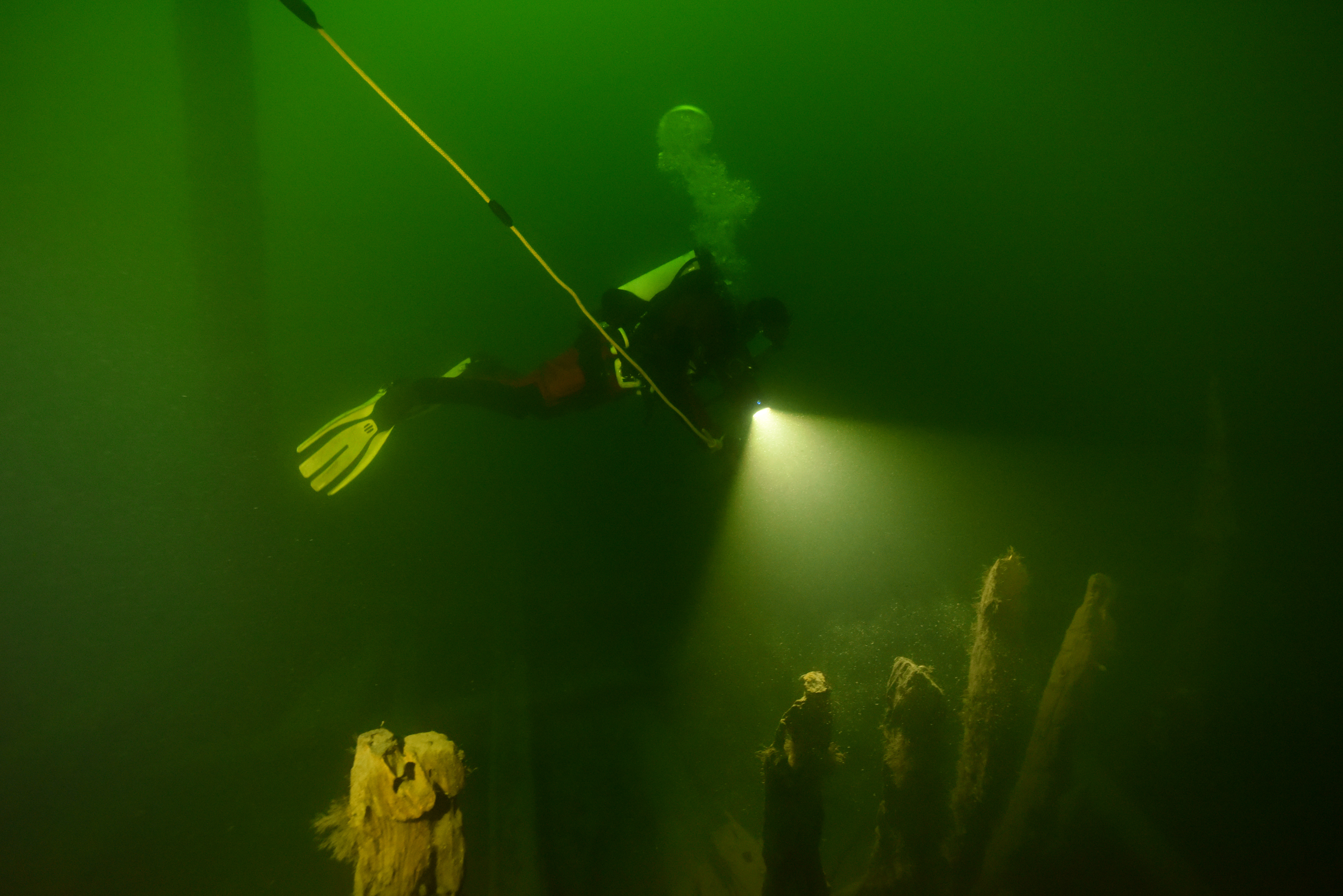 En dykare utforskar ett vrak på havsbotten. 