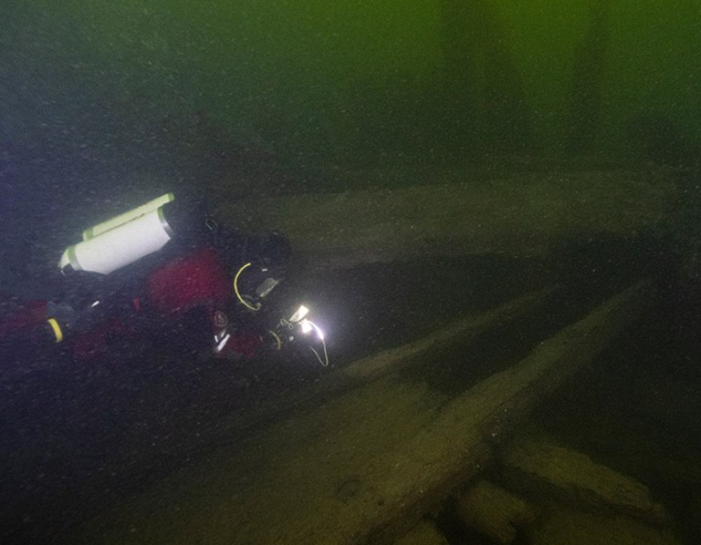 En dykare undersöker ett vrak på havsbotten.