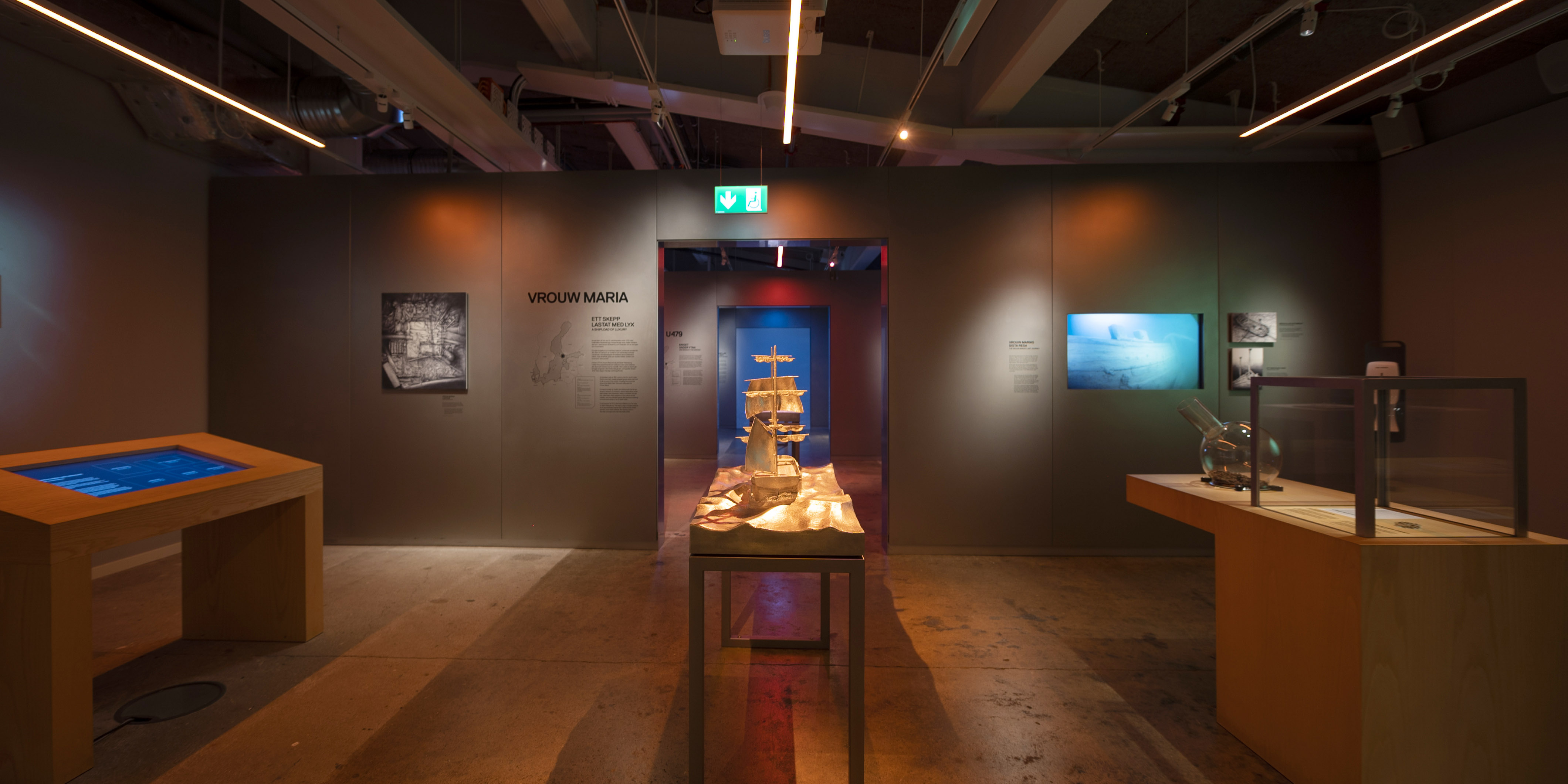 Utställningsrum om skeppet Vrouw Maria med modell av fartyg i mitten och informationskyltar på väggarna.