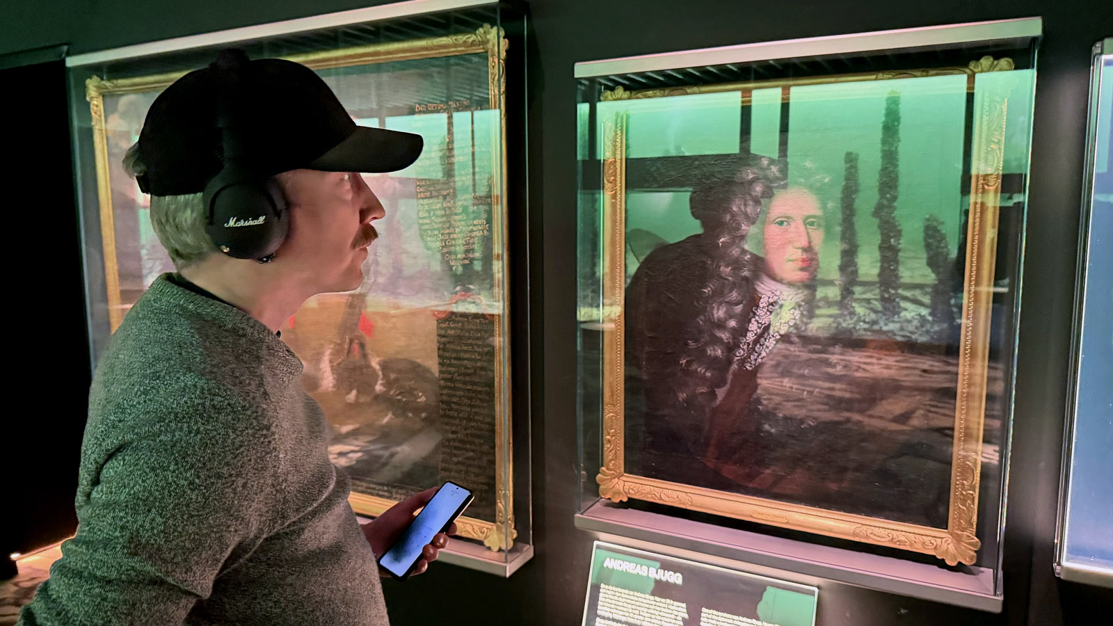 Besökare lyssnar på audioguide i utställningen om Resande Man