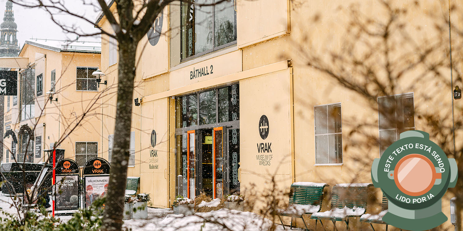 Museet Vrak, en ljusgul byggnad i två våningar med snö på marken. Bilden är märkt med en dykhjälm och texten: Este texto está sendo lido por IA.