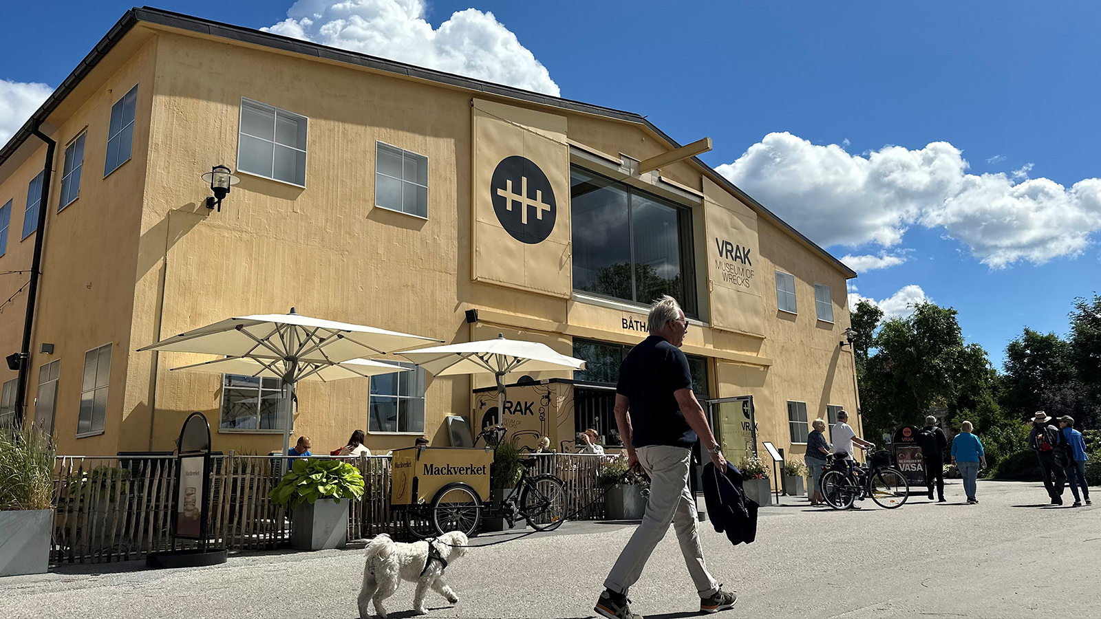 Man med hund promenerar förbi Vrak