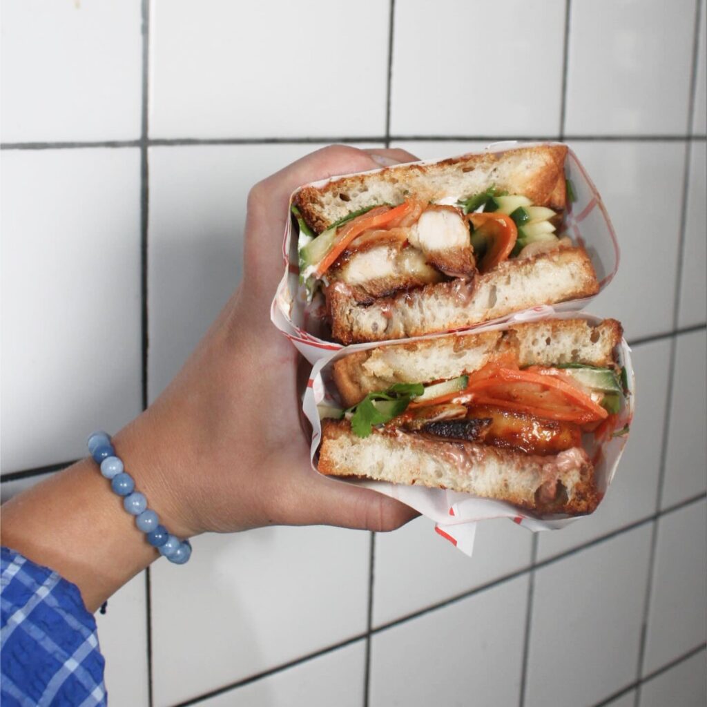 En hand som håller upp en macka