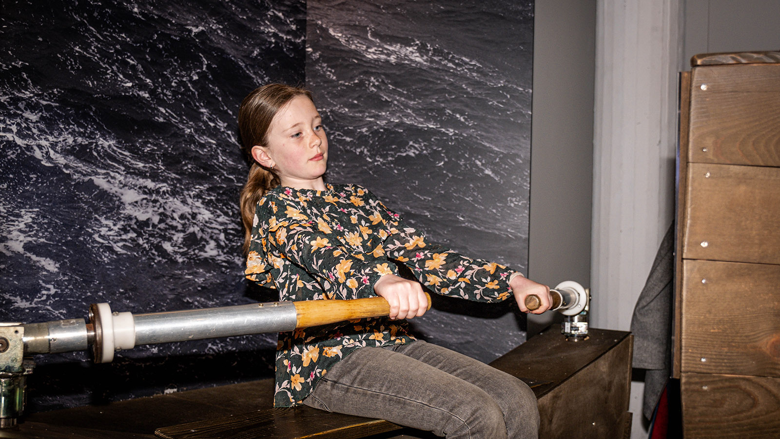 A girl tests the viking exhibition's rowing station
