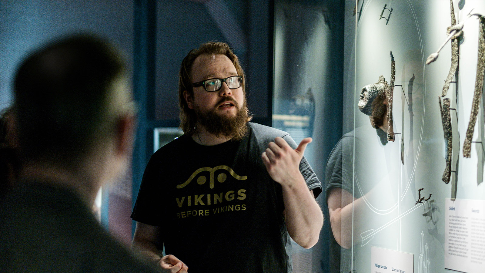 A male guide guides visitors to the exhibition Vikings Before Vikings