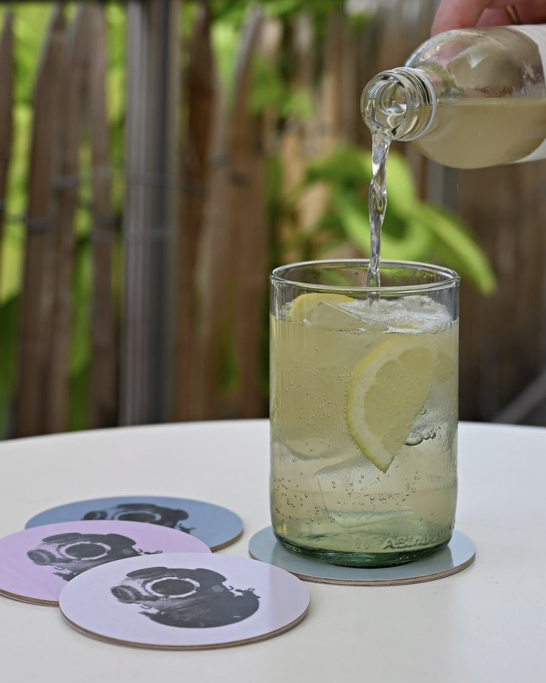 Lemonad hälls upp i ett glas som står på en coaster