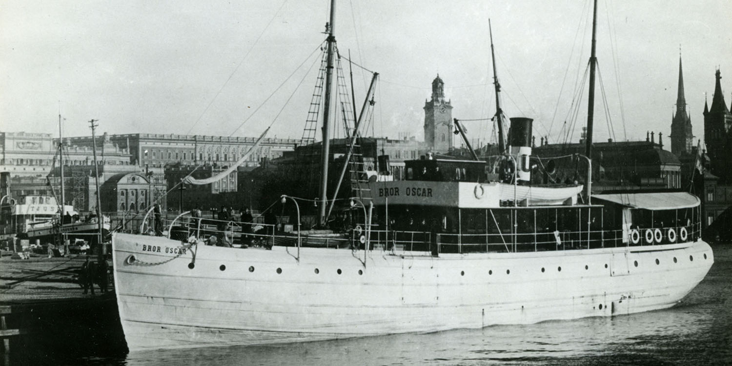 Svartvitt foto av skepp vid brygga, med texten Bror Oscar synligt. Skeppet har master och skorsten.
