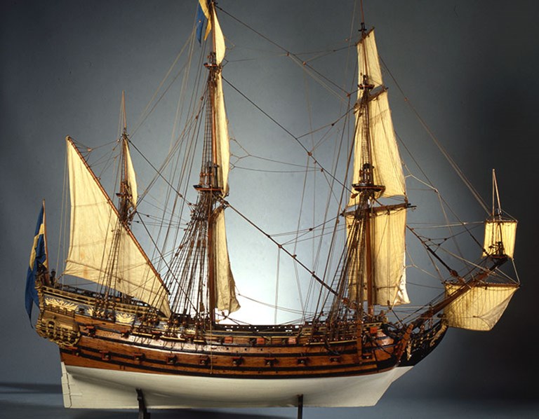 En trämodell av ett äldre skepp med segel.