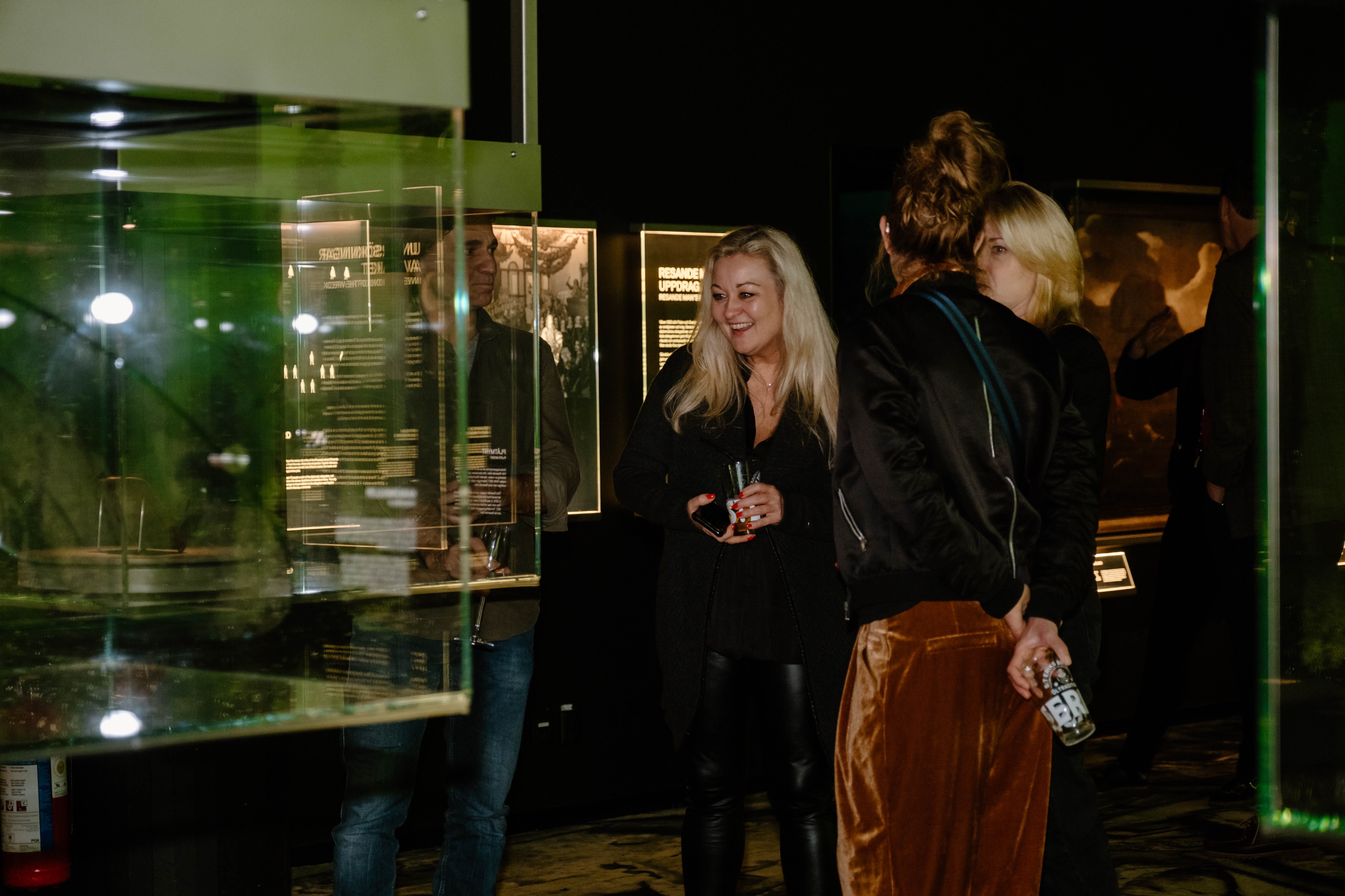 Visitors in the exhibition Resande Man (traveling man) at Vrak - Museum of Wrecks, display cases with holograms are visible. 